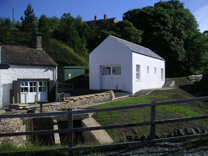 hydroelectric_house.jpg - This is the new hydroelectric house, which has two turbines, one run from Perry's Dam and the other from Handsome Mea (Smallcleugh) Dam. The turbines still use the same Pelton wheel design as the original found at the bottom of the Brewey Shaft.
