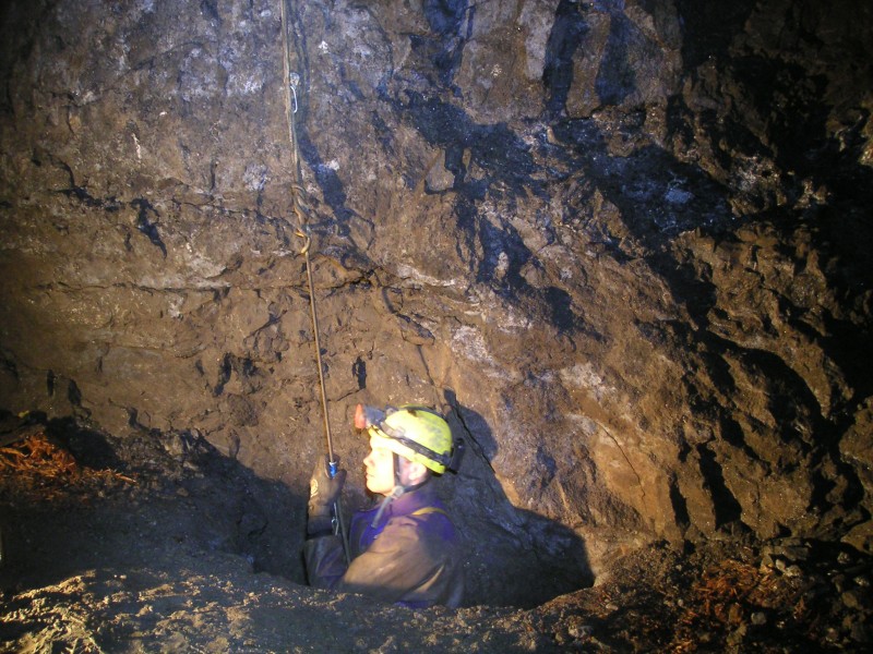 sc_orechutefromboggstopes.jpg - Pete emerging from the ore chute that we rigged up. This is in the Bogg Shaft stope, west side. The original chute for access to Smallcleugh Horse Level is now blocked.