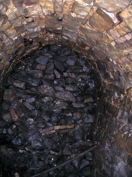 sc_sublevel_walledpassage.jpg - At the southern end of the passage we came to this wall, which we started to think was the same wall that had been built up down Proud's Sump, to stop entry into Carr's. Karli noticed rail tracks with rope attached to them and a bolt in the passage wall, this hinted that there was a shaft on the other side - just like Proud's? We removed a couple of the top stones and sent a rock down, yes definitely a shaft, is this Carr's?