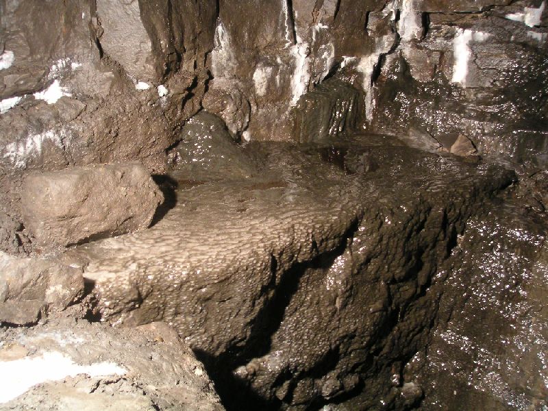 sb_levelbelowtopsills_calflow.jpg - A mottled grey calcite flow hanging over one of the many sumps in the level.