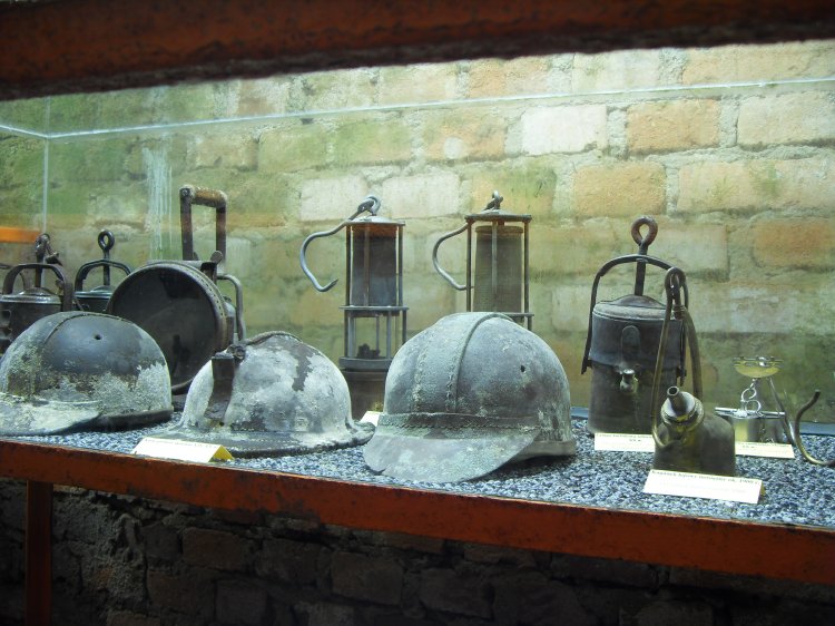 zs_tourist05.jpg - Display of helmets, carbide lamps, safety lamps and powder holder.